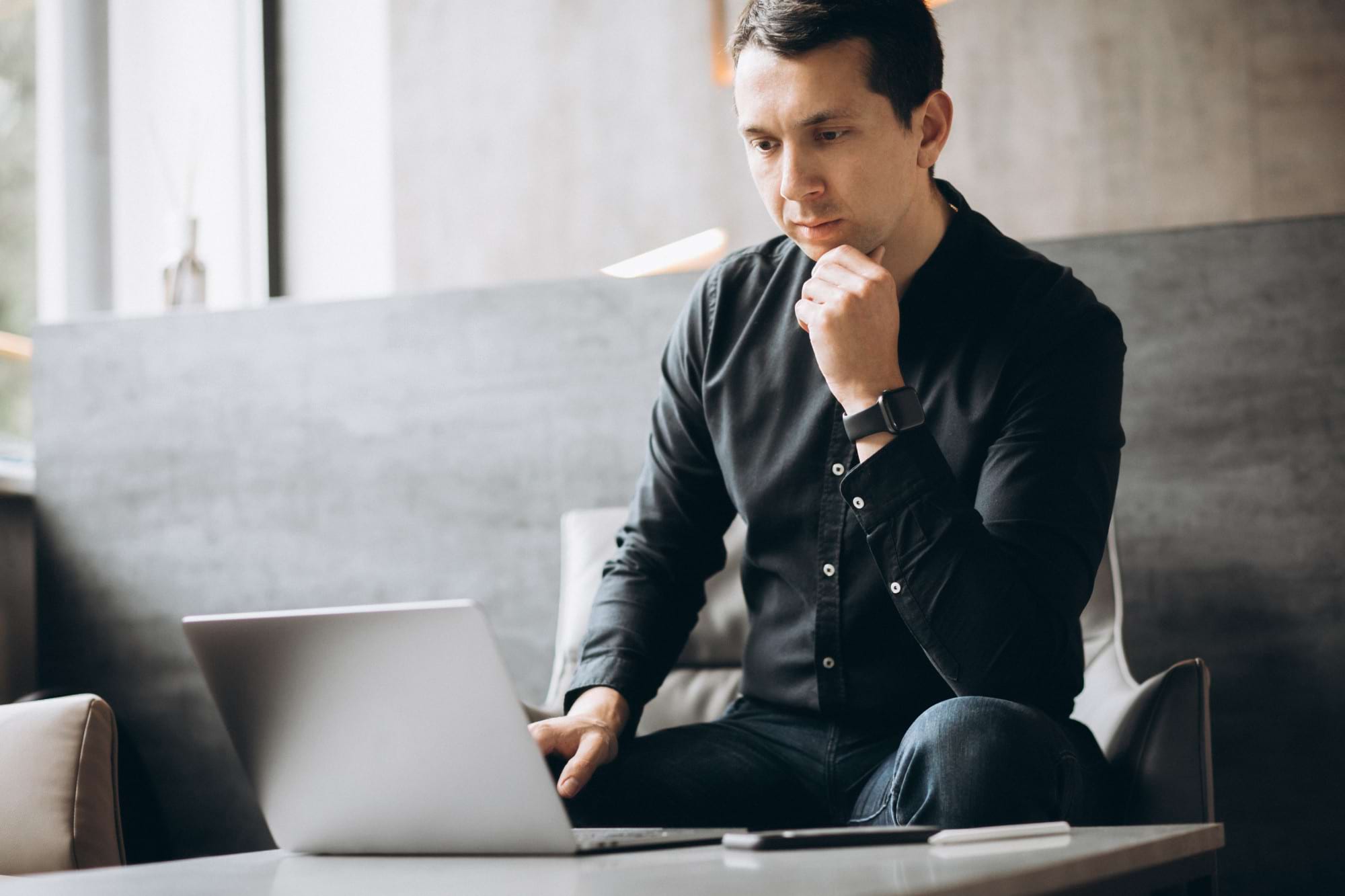 mężczyzna czyta umowę na laptopie